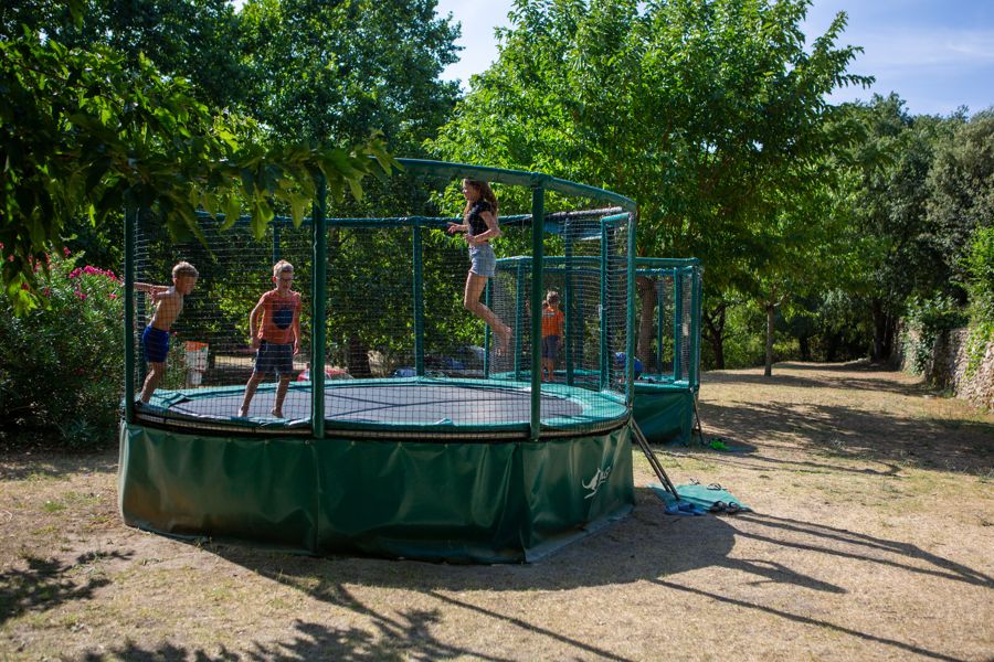 Trampolines in de schaduw van de bomen