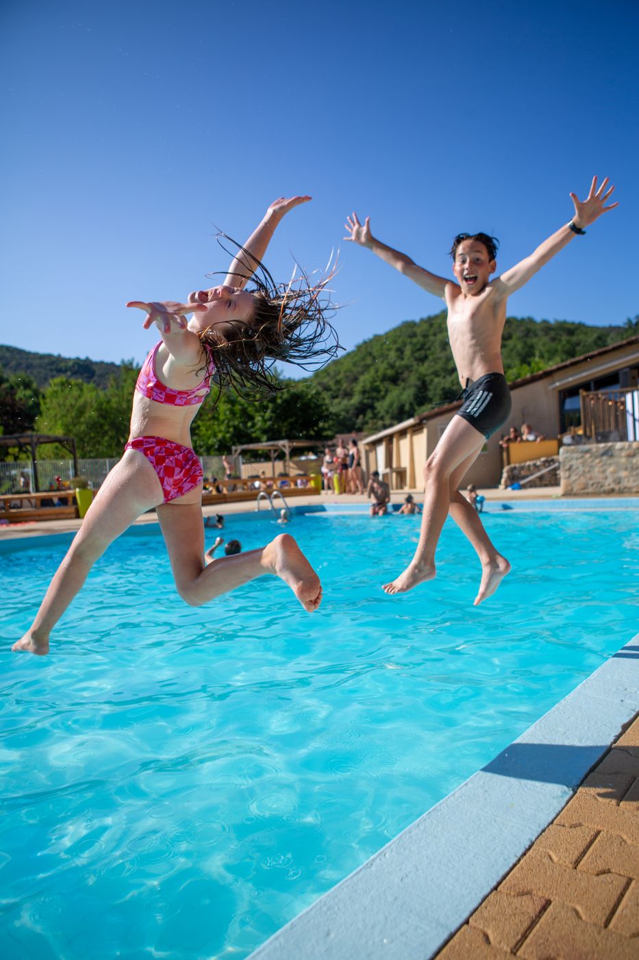 Twee kinderen springen in het zwembad